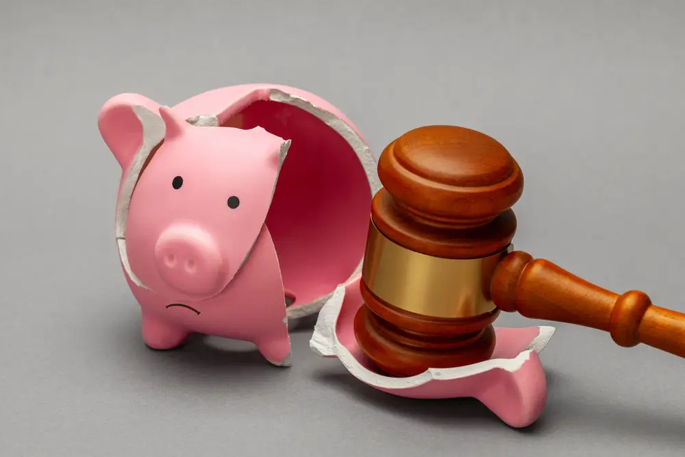Broken piggy bank and judge gavel on gray background. Bankruptcy, crisis concept.